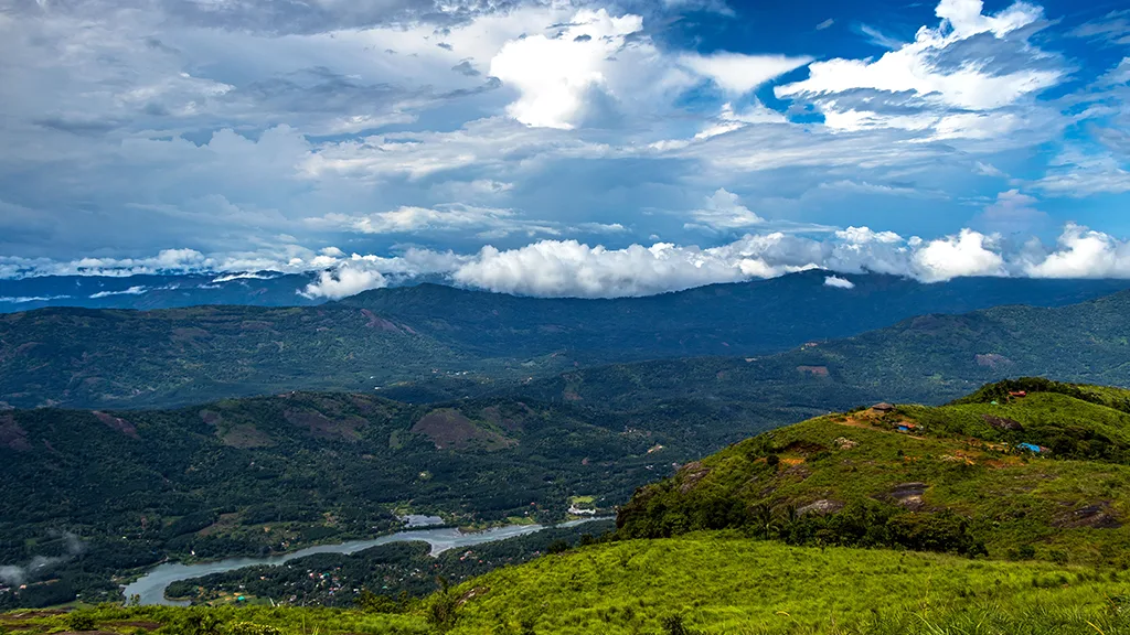 Ilaveezhapoonchira misty landscape at sunrise with rolling green hills and panoramic valley view in Kottayam, Kerala.